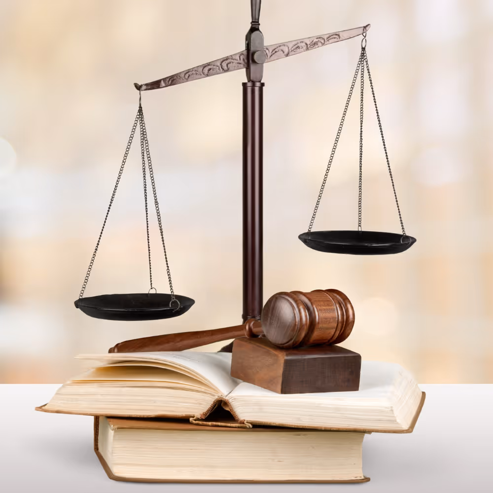 Justice scales and wooden gavel resting on open and closed law books.